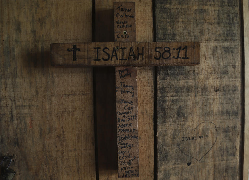 A cross is engraved with a biblical verse and the name of U.S. church members who built the house where the cross hangs, in an area once controlled by gangs, in Santa Ana, El Salvador, Saturday, April 29, 2023. (AP Photo/Salvador Melendez)