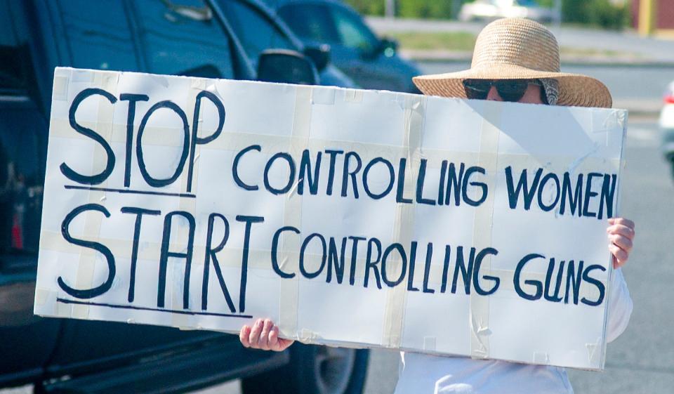 About 20 people gathered along John Sims Parkway on Wednesday to wave signs in support of Roe v. Wade.