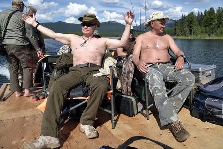 Russian President Vladimir Putin and Defence Minister Sergei Shoigu rest after fishing during the hunting and fishing trip which took place on August 1-3 in the republic of Tyva in southern Siberia, Russia, in this photo released by the Kremlin on August 5, 2017. Sputnik/Alexei Nikolsky/Kremlin via REUTERS