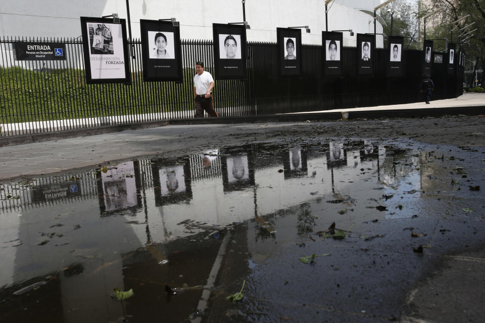 Photographs of the teachers college students who disappeared on Sept. 26, 2014 hang on the fence surrounding the senate building in Mexico City, Wednesday, Sept. 26, 2018. President-elect Andres Manuel Lopez Obrador said Wednesday his administration will accept a truth commission to investigate the case of the 43 missing students, drawing rare praise and expressions of hope from the long-suffering parents of the victims. (AP Photo/Rebecca Blackwell)