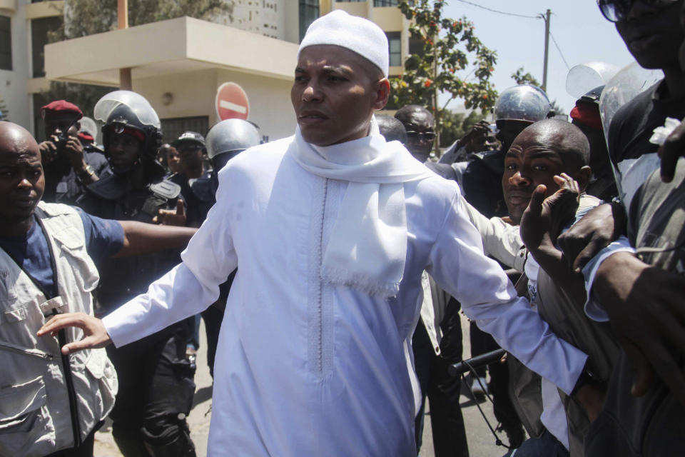 FILE - Karim Wade, centre, leaves the office of the special prosecutor investigating him on charges of embezzled funds, in Dakar, Senegal, on March 15, 2013. Senegal’s top decision-making body has on Saturday, Jan. 20, 2024 published the final list of candidates for next month’s presidential election, excluding two of the West African nation’s top opposition leaders. Among the opposition candidates excluded are frontrunner Ousmane Sonko and Karim Wade, son of former Senegalese President Abdoulaye Wade. (AP Photo, File)