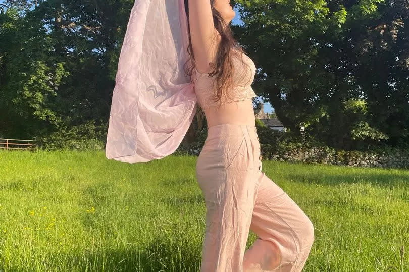 Millie before she became unwell, posing in a field in a pink outfit