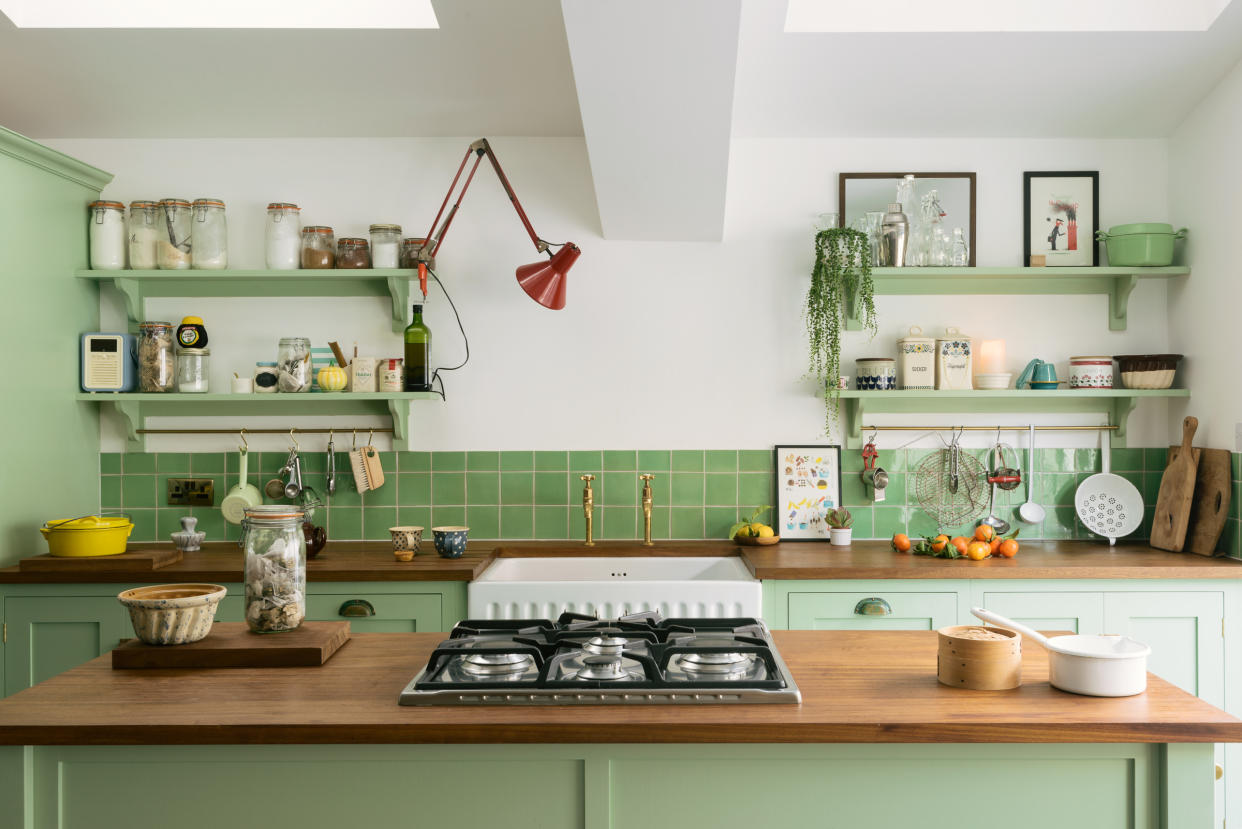  Green kitchen with wooden worktops and island 