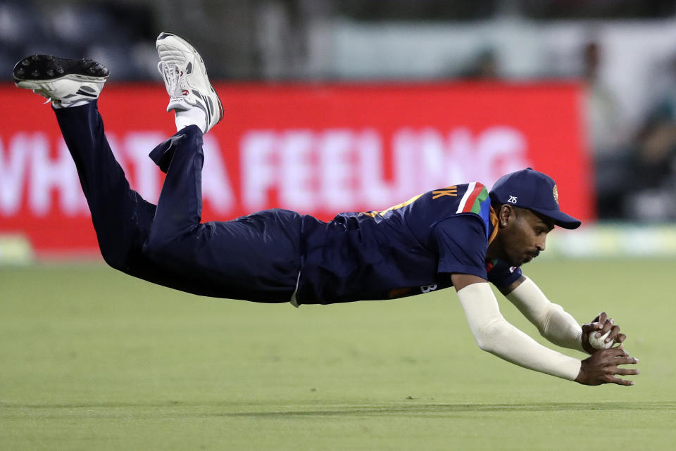 India's Hardik Pandya dives to make a catch to dismiss Australia's Aaron Finch during their T20 international cricket match at Manuka Oval, in Canberra, Australia, Friday, Dec 4, 2020. (AP Photo/Mark Baker)