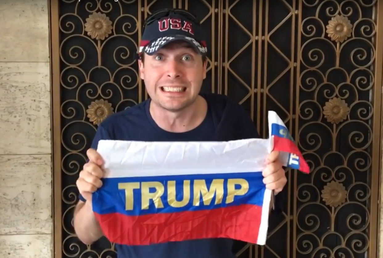 Activist poses with Russian flags which were distributed to Trump at the Conservative Political Action Conference: Youtube/ Americans Take Action