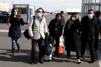 Pasajeros con máscaras faciales salen del crucero Diamond Princess en la Terminal de Cruceros del Muelle Daikoku en Yokohama, al sur de Tokio, Japón, el 19 de febrero de 2020