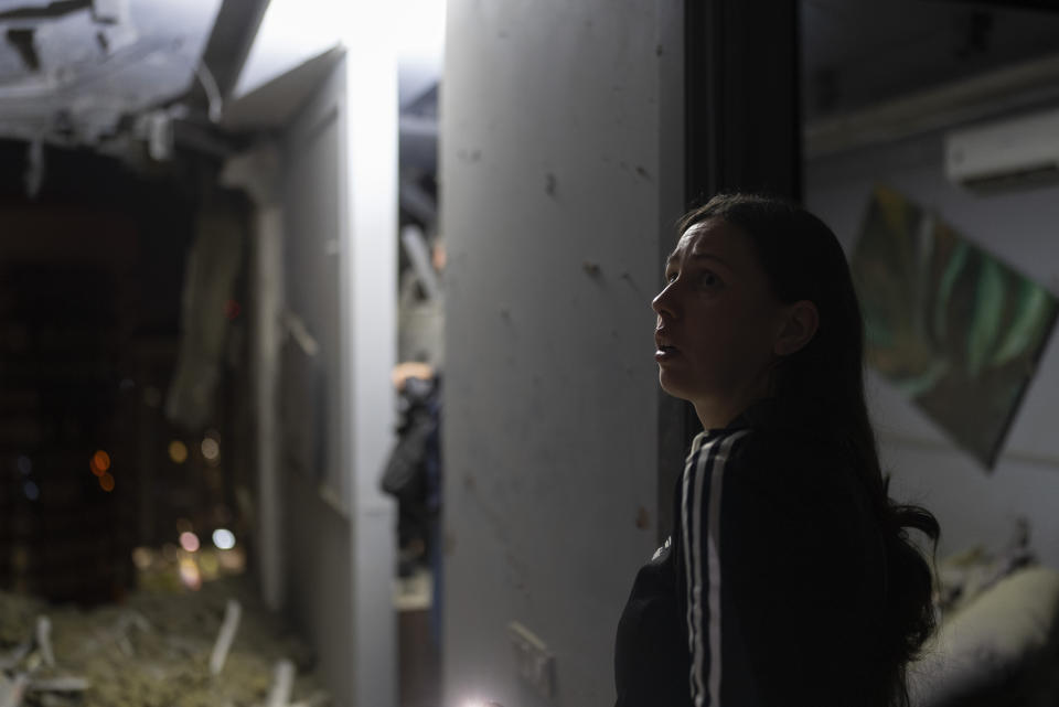 A resident surveys her neighbor's apartment damaged in Russia's air attack in Kyiv, Ukraine, Thursday, July 13, 2023. (AP Photo/Jae C. Hong)