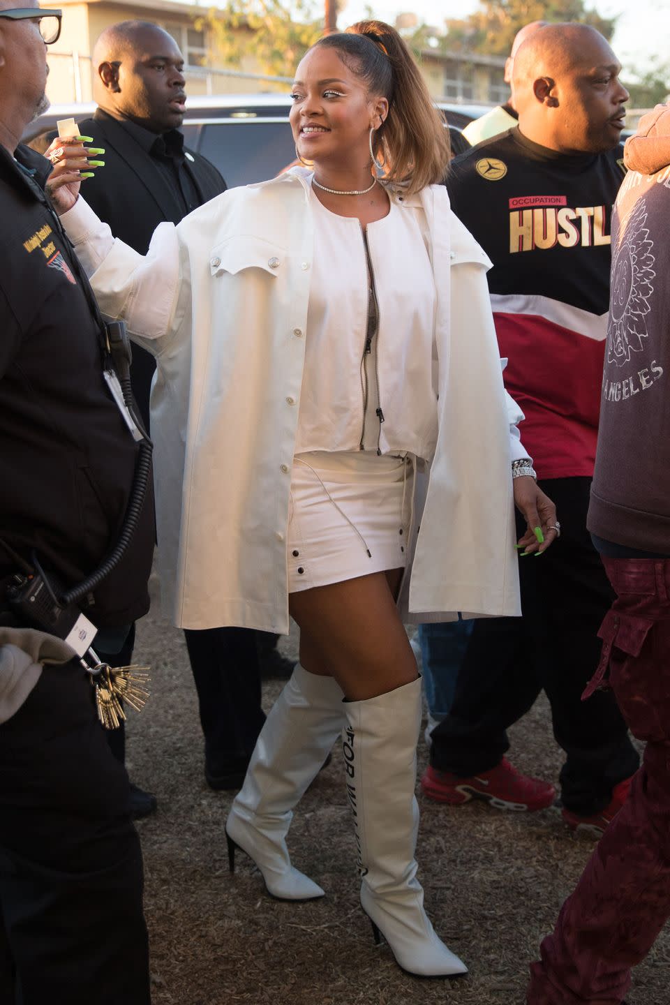 <p>In a white oversized shirt over a cropped zip-up jacket and mini skirt by Tom Ford, Off-White "For Walking" boots, hoop earrings, and a diamond choker necklace after performing with Kendrick Lamar at the annual TDE Christmas Concert in Watts, CA.</p>