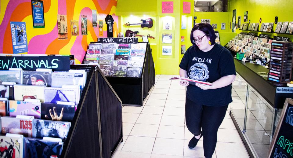 Liz Cochran, the owner of Stellar Records in Fort Myers stocks merchandise on Thursday, April 11, 2024. The store sells new and vintage vinyl records, cassette tapes, vintage decor and more. The store will take part in Record Store Day, where U.S. record stores sell cool, limited-edition vinyl records. The event is on April 20.