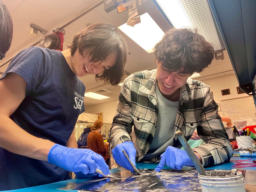 Satellite Research Team members Galen Gilmore, left, and Jonathan House work on a student-designed printed circuit board.