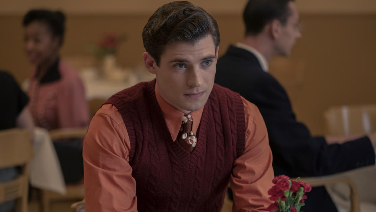  David Corenswet sitting at a table dressed in red and pink in Hollywood. 