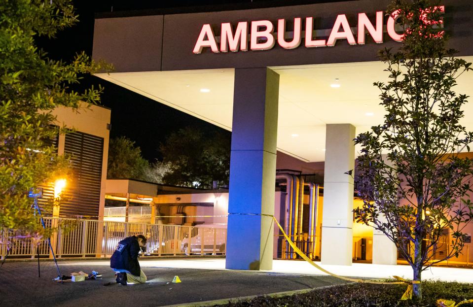 A Florida Department of Law Enforcement Forensic Unit photographer takes pictures of some evidence early Tuesday while working the scene of a deputy-involved shooting outside AdventHealth Ocala hospital.