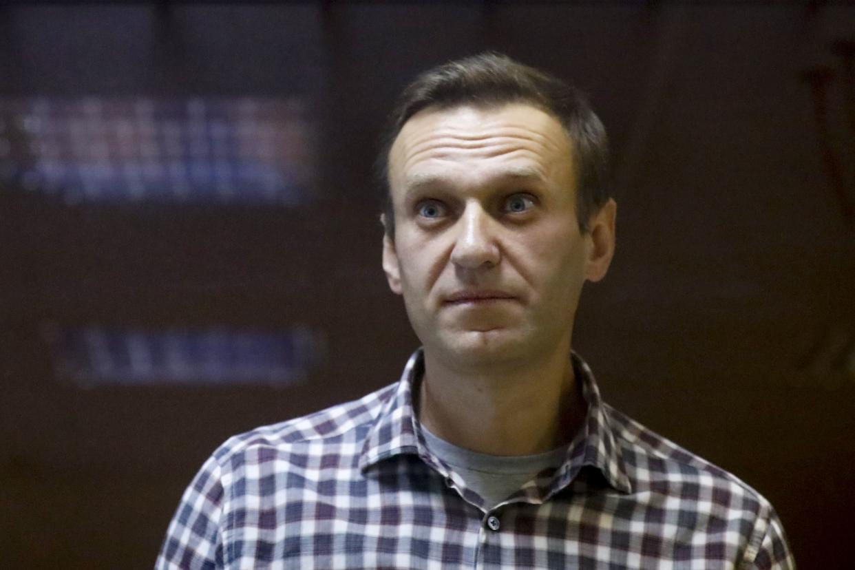 Russian opposition leader Alexei Navalny stands in a cage in the Babuskinsky District Court in Moscow, Russia, on Saturday, Feb. 20, 2021. 