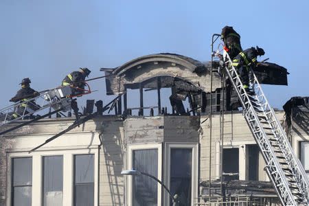 Firefighters battle a four-alarm blaze in a three-story apartment building in Oakland, California, U.S. March 27, 2017. REUTERS/Beck Diefenbach