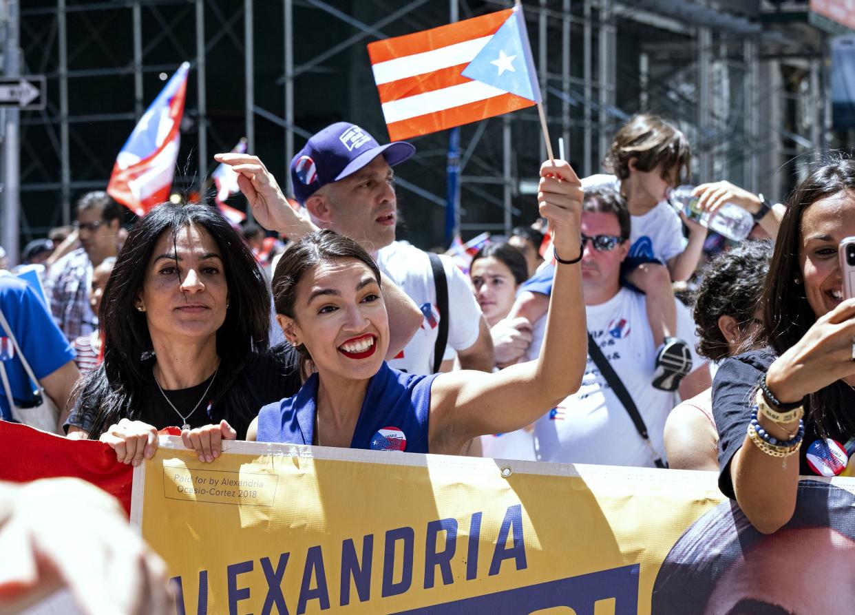 Rep. Alexandria Ocasio-Cortez, D-N.Y., center, takes part in the National Puerto Rican Day Parade, Sunday, June 9, 2019, in New York. 