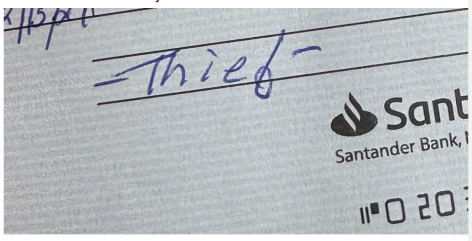 The image shows a close-up of a check with "Thief" written on the memo line, implying a dispute over owed compensation