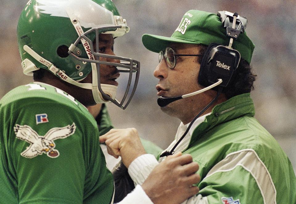 Philadelphia Eagles coach Rich Kotite, right, talks with quarterback Randall Cunningham during the first quarter of playoff game against the Dallas Cowboys, Sunday, Jan. 10, 1993, in Irving, Texas.