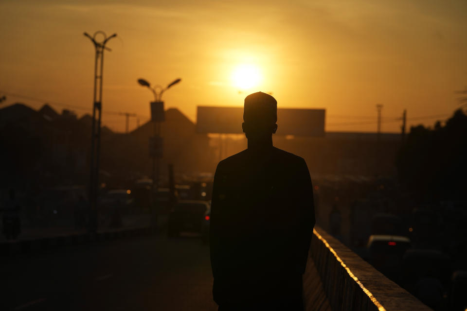 An atheist stands against the sunset sky in a street in Kano, Nigeria Friday, July 14, 2023. Nonbelievers in Nigeria said they perennially have been treated as second-class citizens in the deeply religious country whose 210 million population is almost evenly divided between Christians dominant in the south and Muslims who are the majority in the north. Some nonbelievers say threats and attacks have worsened in the north since the leader of the Humanist Association of Nigeria, Mubarak Bala, was arrested and later jailed for blasphemy. (AP Photo/Sunday Alamba)