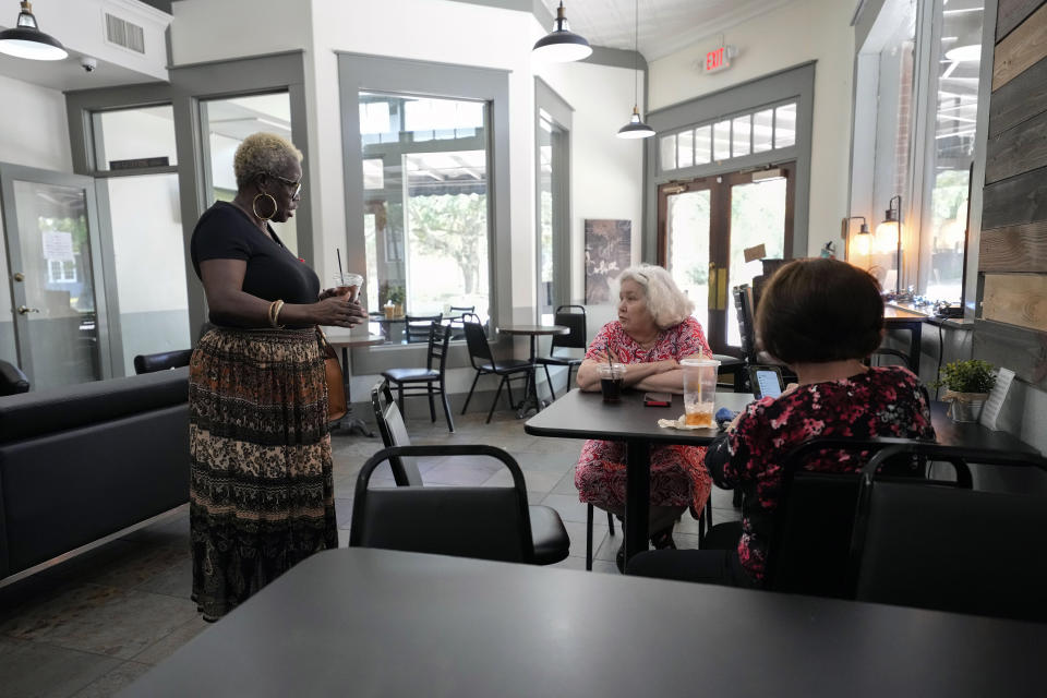 FILE - Betty Shinn talks to a neighbor and her neighbor's friend at a coffee shop in in Mobile, Ala., June 2, 2023. A U.S. Supreme Court decision a decade ago that tossed out the heart of the Voting Rights Act continues to reverberate across the country. Republican-led states continue to pass voting restrictions that, in several cases, would have been subject to federal review had the court left the provision intact. Alabama could add another to the list soon, one that would make it a crime to help a non-family member fill out or return an absentee ballot. "This is voter suppression at its best," said Shinn, who recently testified against the bill during a legislative hearing in Montgomery. "It's no different from asking me how many jellybeans are in that jar or asking me to recite the Constitution from memory." (AP Photo/Gerald Herbert)