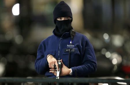 A Belgian police officer searches the area during a continued high level of security following the recent deadly Paris attacks, in Brussels, Belgium, November 22, 2015. REUTERS/Francois Lenoir TPX IMAGES OF THE DAY