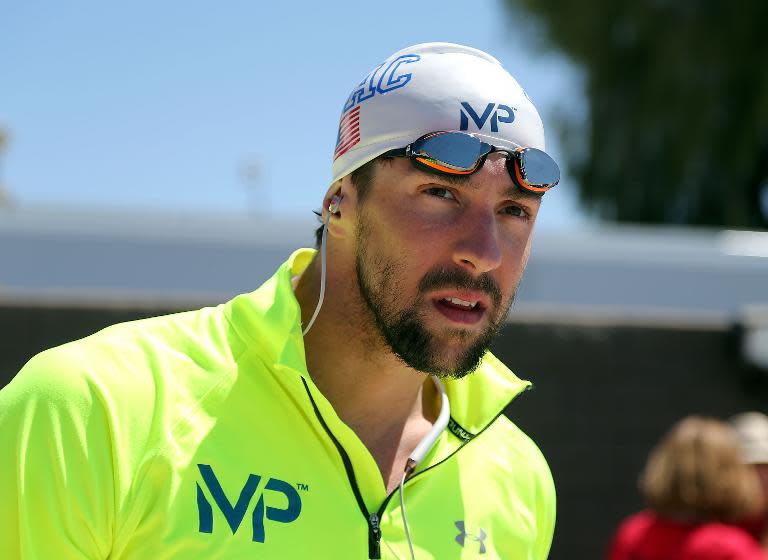 Michael Phelps watches a race before competing in the 400m freestyle prelim during day three of the Arena Pro Swim Series, at the Skyline Acquatic Center in Mesa, Arizona, on April 17, 2015