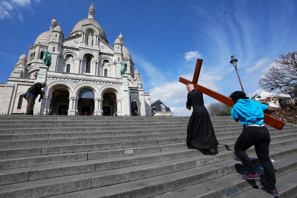 Faithfuls carry a wooden cross as part of Easter celebrations in Paris on Good Friday 2022.