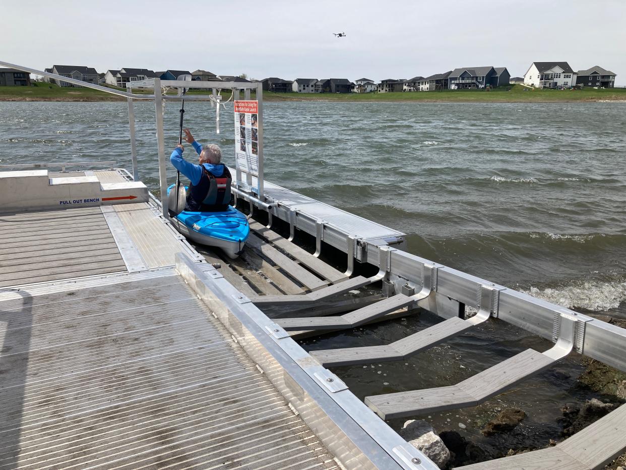 Altoona Mayor Dean O'Connor demonstrates how to use the first-of-its-kind boat launch at Spring Creek Park at a ribbon cutting event on April 22. The launch makes getting into and out of the water when using small boats, such as kayaks and canoes.