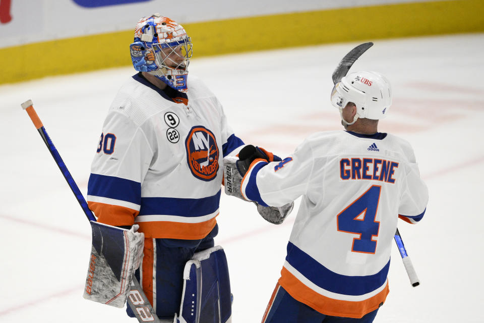 New York Islanders goaltender Ilya Sorokin (30) and defenseman Andy Greene (4) celebrate after an NHL hockey game against the Washington Capitals, Tuesday, April 26, 2022, in Washington. The Islanders 4-1. (AP Photo/Nick Wass)