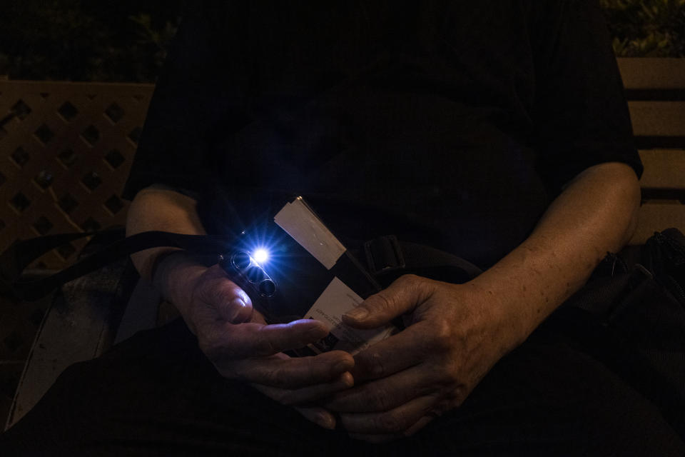 A member of the public shine the light of his smartphone near Victoria Park, the city's venue for the annual 1989 Tiananmen massacre vigil, on the 34th anniversary of China's Tiananmen Square crackdown in Hong Kong, Sunday, June 4 2023. (AP Photo/Louise Delmotte)