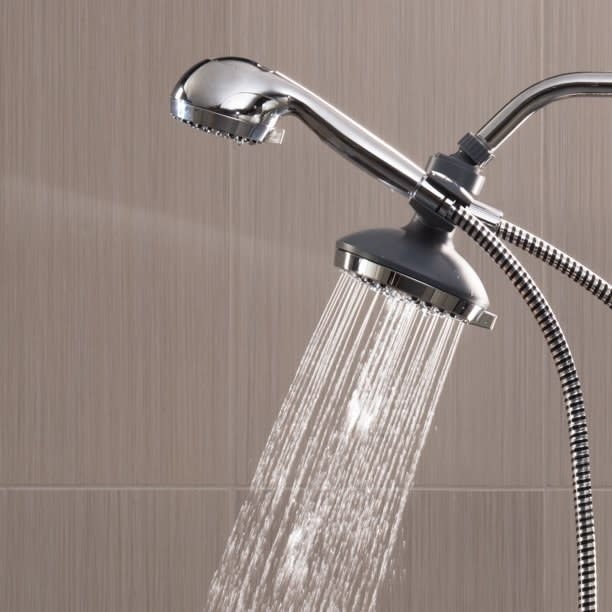 Wall-mounted showerhead with running water and flexible hose, potential for home bathroom upgrade