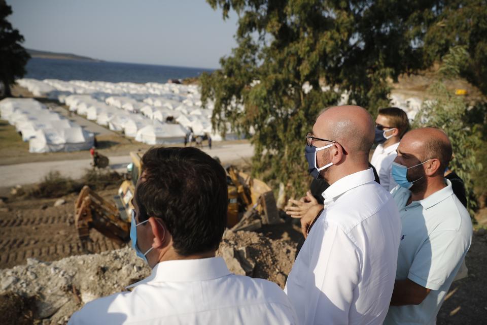 European Council President Charles Michel, center, accompanied by Greek officials, looks at the new temporary refugee camp in Kara Tepe during his visit on the northeastern island of Lesbos, Greece, Tuesday, Sept. 15, 2020. Greece has called on the European Union to jointly run new refugee camps being built on its eastern islands as part of a planned overhaul of the bloc's migration policy. (Dimitris Tosidis/Pool via AP)