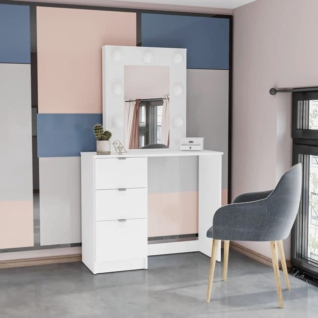 a white makeup vanity in a pink and blue room