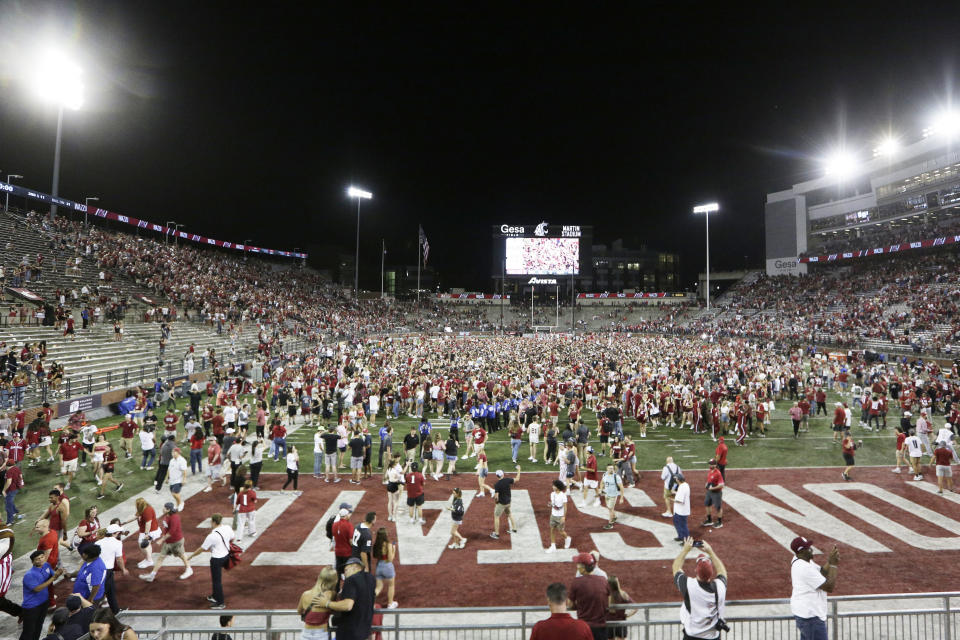 Washington State fans celebrate on the field after team's win over Wisconsin in an NCAA college football game, Saturday, Sept. 9, 2023, in Pullman, Wash. (AP Photo/Young Kwak)