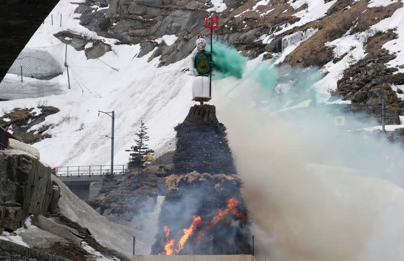 The Boeoegg, a snowman, stands atop of a bonfire on Devil's Bridge near Andermatt