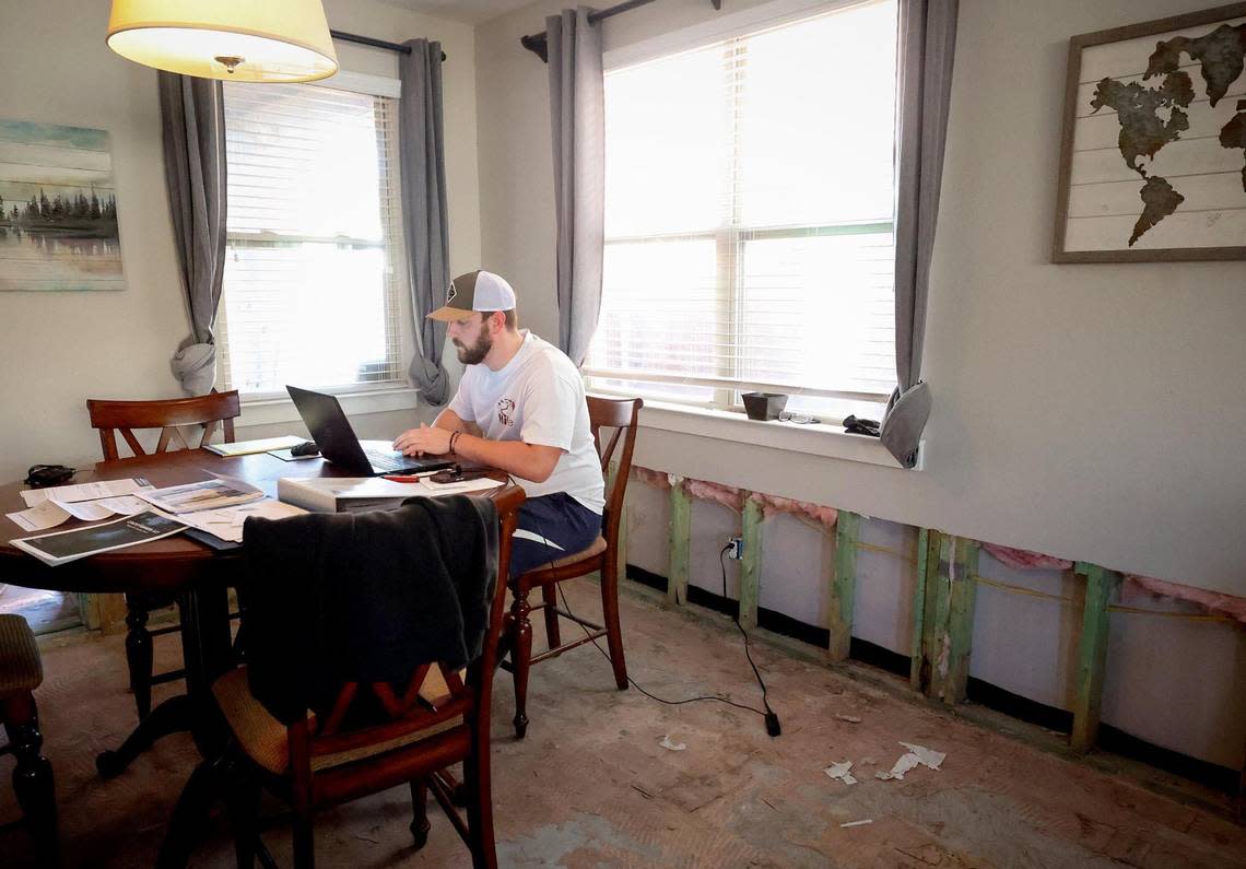 Dane Wicks sits at his dining room table while working from home in the Linwood neighborhood of Fort Worth. Wicks is still in the process of repairing his townhome after severe flooding last summer caused around $80,000 in damage.