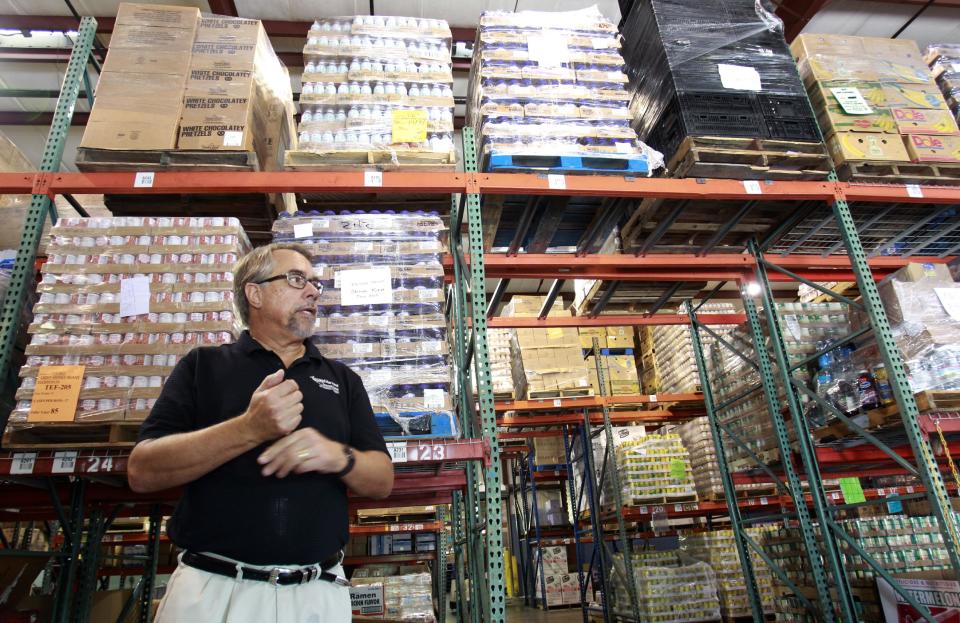 In this Monday, July 30, 2012 photo, Dave Krepco, director of the Second Harvest Food Bank, checks on inventory at the food bank warehouse in Orlando, Fla. In the past four years, food distribution to 500 pantries, shelters, and other relief agencies in the six-county area has jumped about 60 percent. In the last year alone, that amounted to 36 million pounds of food. Krepcho estimates about 30 percent of those seeking help are first-timers. They're blue-collar and white-collar, many middle class, even some upper middle class. They include college-educated couples and professionals. (AP Photo/John Raoux)