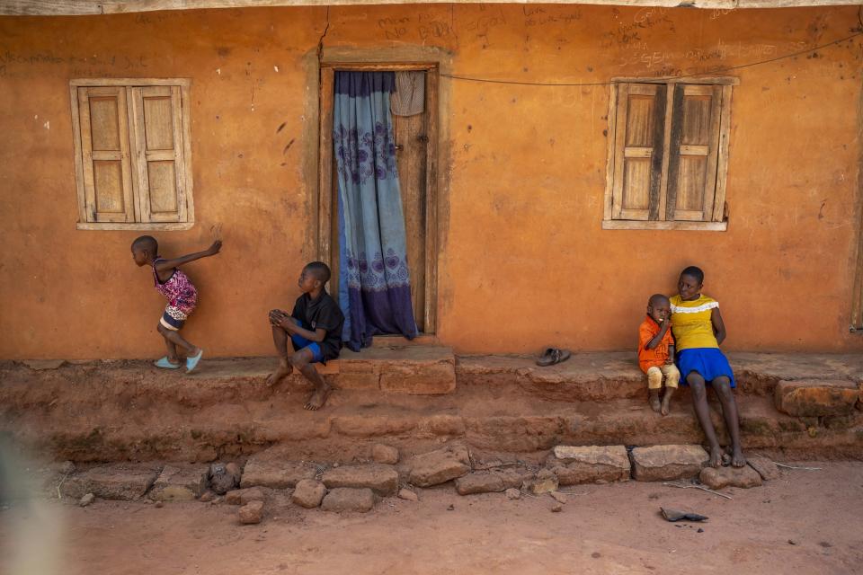 Roseline Ujah's children play outside her home in Umuida, Nigeria, Friday, Feb. 11, 2022. Ujah's husband Godwin fell severely ill with a fever and cough. Everyone assumed at first that the palm wine tapper had contracted malaria, but then he failed to improve on medications for that disease. Doctors at a local hospital diagnosed him with COVID-19, though there were no tests available locally to confirm their suspicion. (AP Photo/Jerome Delay)