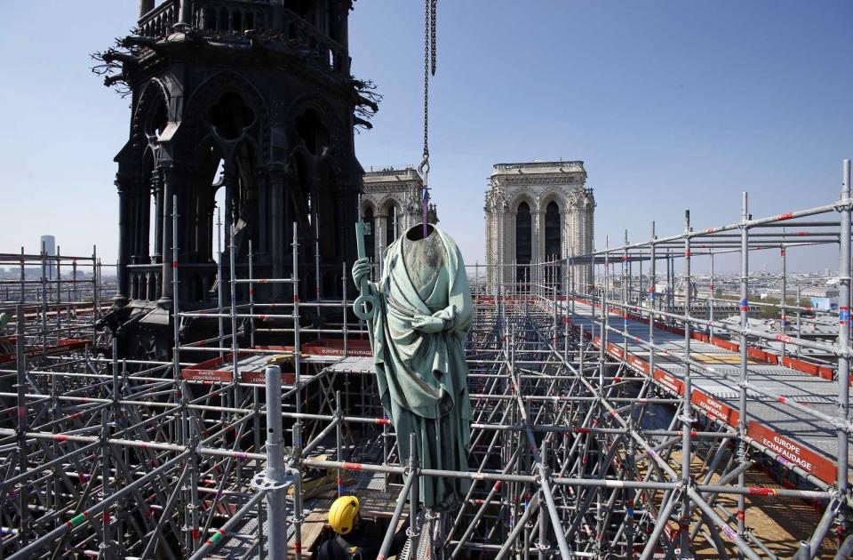 A religious statue is removed from the spire of Notre Dame cathedral by a crane before restoration work on April 11, 2019 in Paris, France.