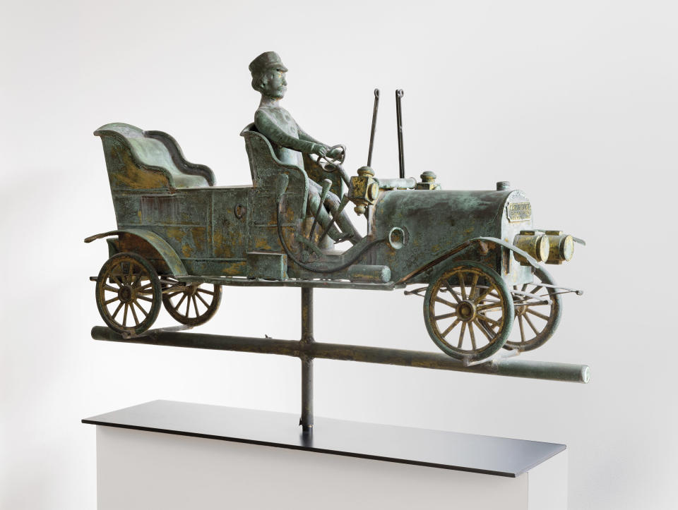 This image provided by the American Folk Art Museum shows a Touring Car and Driver weather vane. Perched atop churches, barns, businesses, homes and seats of government for hundreds of years, weather vanes have taken the form of everything from farm animals to pets, storybook figures to race cars. They were invented for one important job: telling which way the wind was blowing. Gradually, they became appreciated as an art form. (Adam Reich/American Folk Art Museum via AP)
