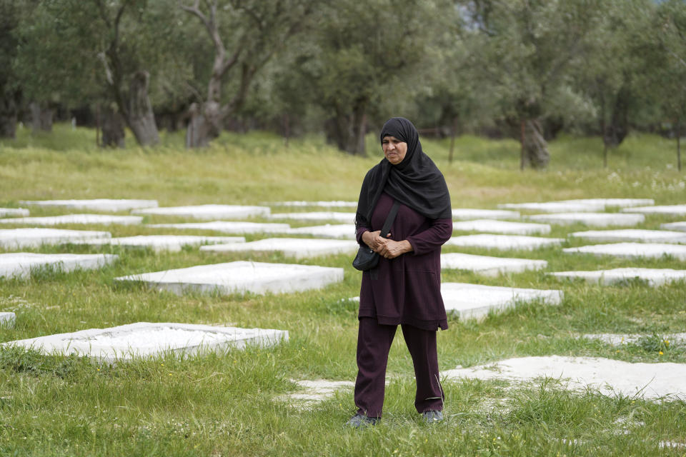 A woman walks at the cemetery in Kato Tritos village on the northeastern Aegean Sea island of Lesbos, Greece, on Wednesday, April 17, 2024. After years of neglect, a primitive burial ground for refugees who died trying to reach Greece's island of Lesbos has been cleaned up and redesigned to provide a dignified resting place for the dead. (AP Photo/Panagiotis Balaskas)