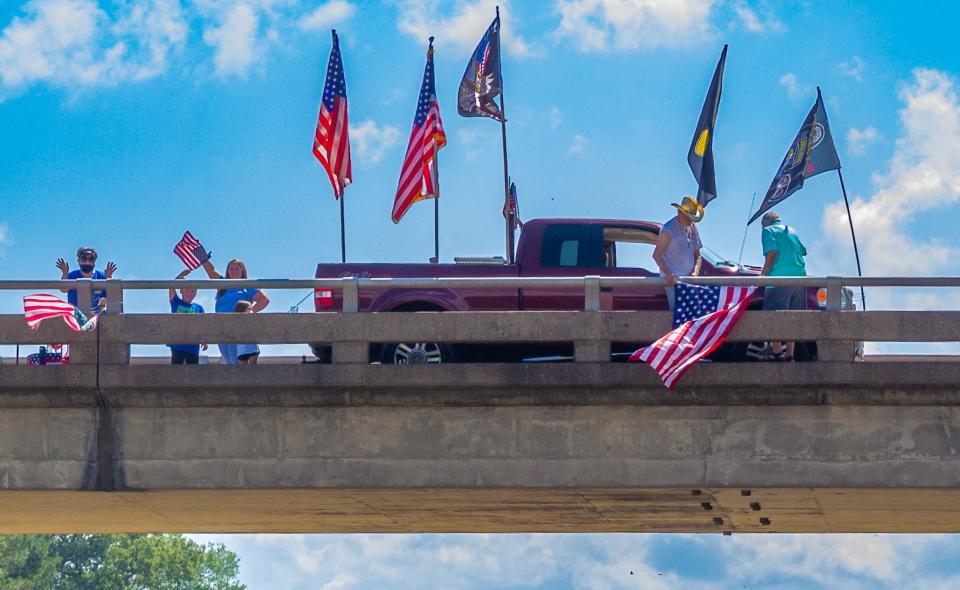 Bystanders wave to passing motorcyclists from an overpass on May 20, 2024, the last Honor Trail veteran’s event in Jackson.