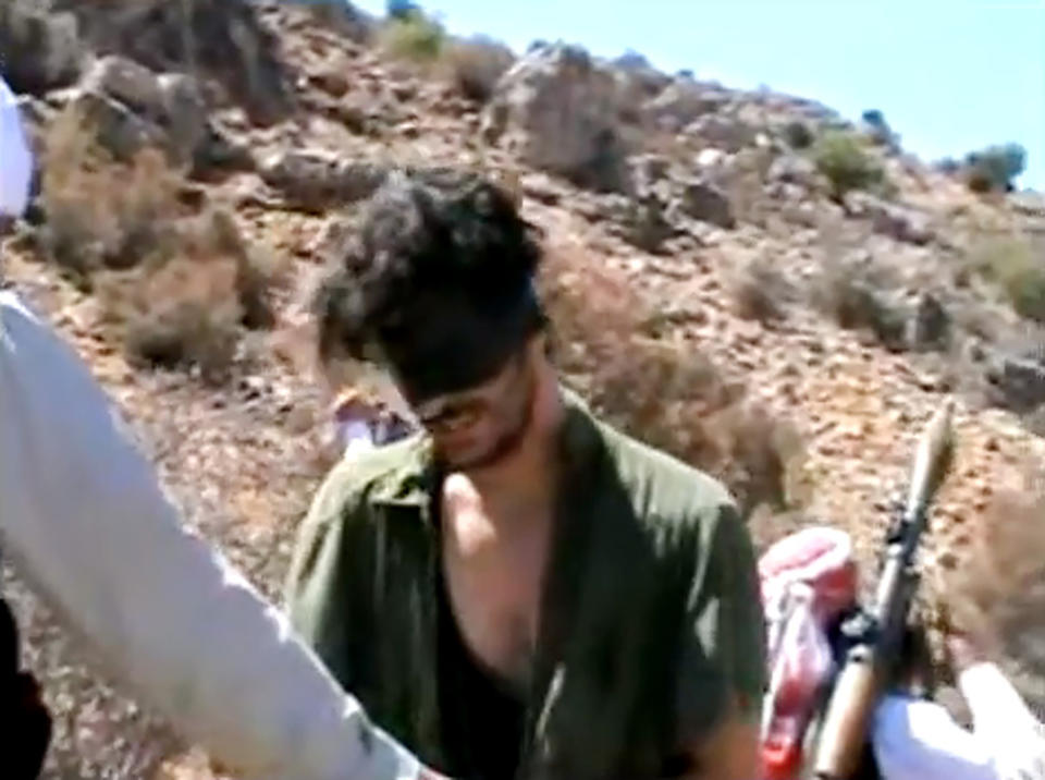 FILE - In this image taken from undated video posted to YouTube, American freelance journalist Austin Tice, who had been reporting for American news organizations in Syria until his disappearance in August 2012, prays in Arabic and English while blindfolded in the presence of gunmen. Syria denied on Wednesday, Aug. 17, 2022, that it is holding Tice or other Americans after President Joe Biden accused the Syrian government of detaining him. (AP Photo, File)