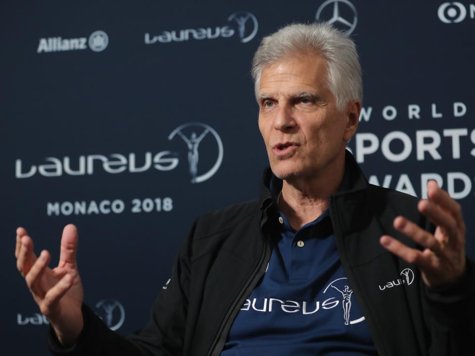 Mark Spitz using his hands to talk in front of wall