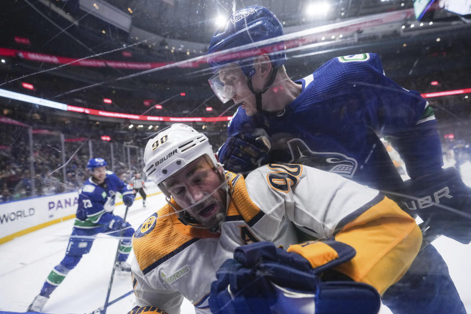 Vancouver Canucks' Tyler Myers, back right, checks Nashville Predators' Ryan O'Reilly during the second period in Game 1 of an NHL hockey Stanley Cup first-round playoff series, in Vancouver, British Columbia, Sunday, April 21, 2024. (Darryl Dyck/The Canadian Press via AP)
