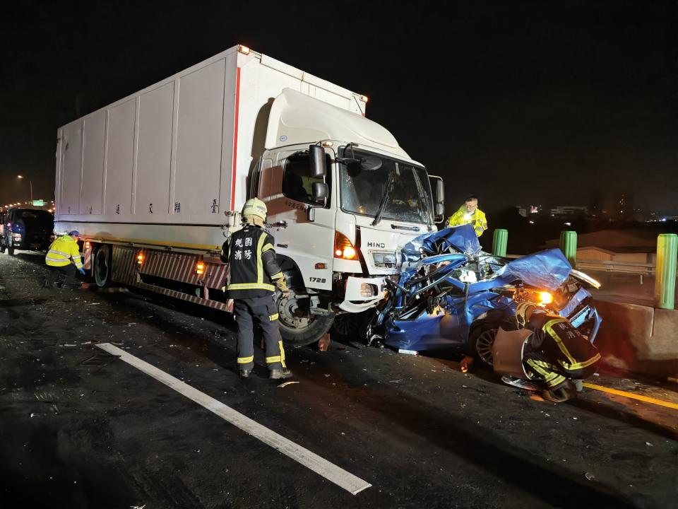 <strong>藍色轎車被大貨車撞成廢鐵，一人卡在車底，車上兩人受困。（圖／翻攝畫面）</strong>