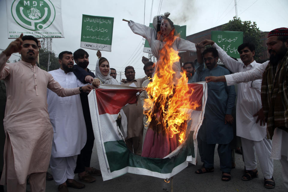 Pakistani people burn an effigy depicting former Bharatiya Janata Party spokeswoman Nupur Sharma during a demonstration to condemn derogatory references to Islam and the Prophet Muhammad recently made by Sharma, a spokesperson of the governing Indian Hindu nationalist party, Friday, June 10, 2022, in Peshawar, Pakistan. (AP Photo/Mohammad Sajjad)