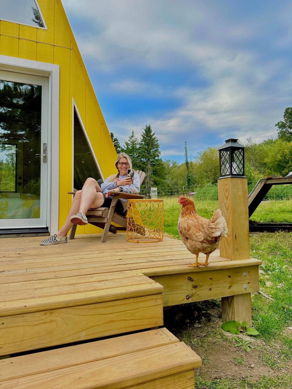 A chicken visits the front porch of the Cheese Wedge Cabin Airbnb, which Etienne White owns on her working sheep farm in Highland, Wisc.