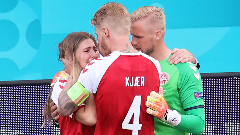 Pictured here, Danish captain Simon Kjaer and goalkeeper Kasper Schmeichel console Eriksen's shattered partner.