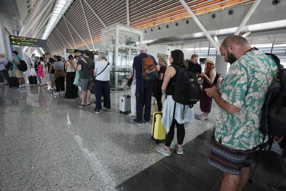 Tourists line up for boarding at the International Airport in Siem Reap province, Cambodia, as it opens Thursday, Nov. 16, 2023. The new airport can handle 7 million passengers a year, with plans to augment it to handle 12 million passengers annually from 2040. It was constructed under a 55-year build-operate-transfer (BOT) program between Cambodia and China. (AP Photo/Heng Sinith)