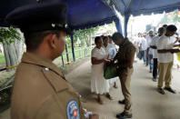 Police officers search the bags of the worshipers at an entrance of the Kelaniya Buddhist temple during Vesak Day, commemorating the birth, enlightenment and death of Buddha, in Colombo, Sri Lanka May 18, 2019. REUTERS/Dinuka Liyanawatte